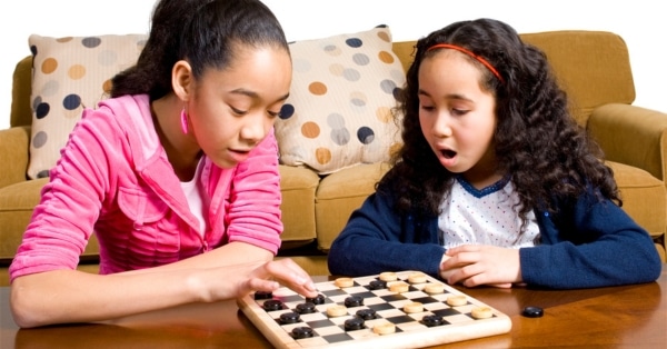 two young girls playing checkers